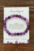 Amethyst bracelet on a card with descriptive text on a wooden surface