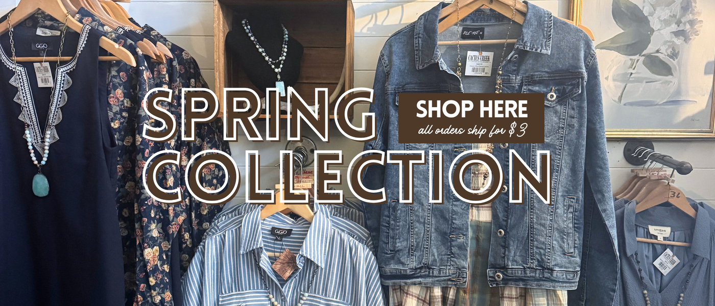 Spring collection display with clothing and jewelry, featuring a 'Shop Here' sign.