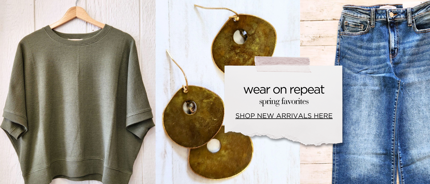 Green sweater on a hanger, jeans, and decorative items with a 'wear on repeat' sign.