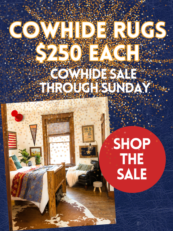 Advertisement for cowhide rugs with a bedroom scene and sale information.